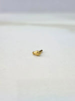 Front view of a small gold nose pin on a white background emphasizing its delicate design