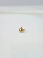 Front view of a tiny gold nose pin on a white background displaying its compact size