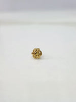 Slight side view of the gold nose pin on a white surface highlighting its lightweight and delicate design
