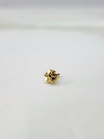 Front view of a tiny gold nose pin on a white background showing its compact size and fine detailing