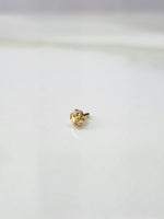 Front view of a miniature gold nose pin placed on a white background highlighting compact design