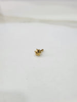 Tiny gold nose pin placed on a white background showing its compact size and fine detailing