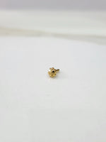 Small gold nose pin placed on a white background displaying fine detailing and compact proportions