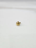 Front view of a tiny gold nose pin placed on a white background showing its compact size and neat design