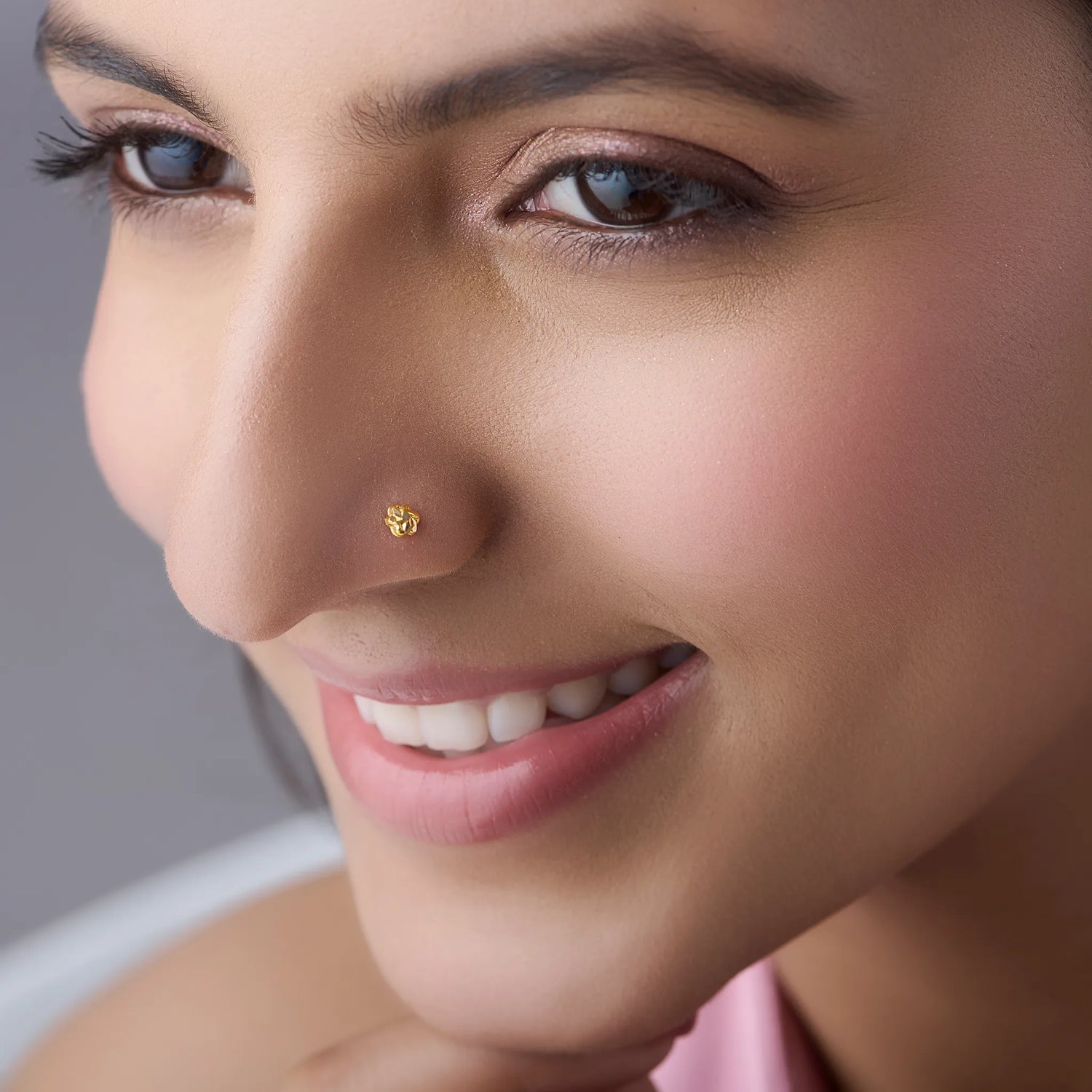 Woman wearing a delicate 18K gold nose pin showcasing an elegant everyday look