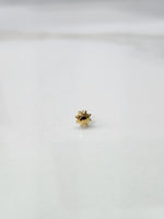 Side view of a lightweight gold nose pin on a white surface showing its compact size and fine finish