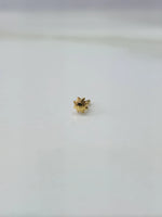 Front view of a tiny gold nose pin placed on a white background highlighting its minimal design