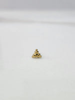 Side angle view of small 18k gold nose pin on white surface for clearer detailing