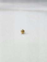 Side view of a lightweight gold nose pin on a white surface emphasizing its compact size and smooth finish