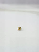 Front view of a delicate gold nose pin placed on a white background showing fine craftsmanship