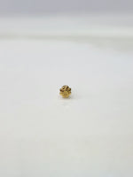 Side view of a tiny gold nose pin on a white surface emphasizing fine craftsmanship