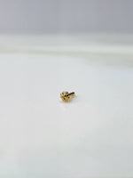 Front view of a tiny gold nose pin placed on a white background highlighting its minimal design and size