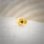 Close up of elegant floral gold nose pin design crafted in 18k yellow gold featuring soft petal detailing for women