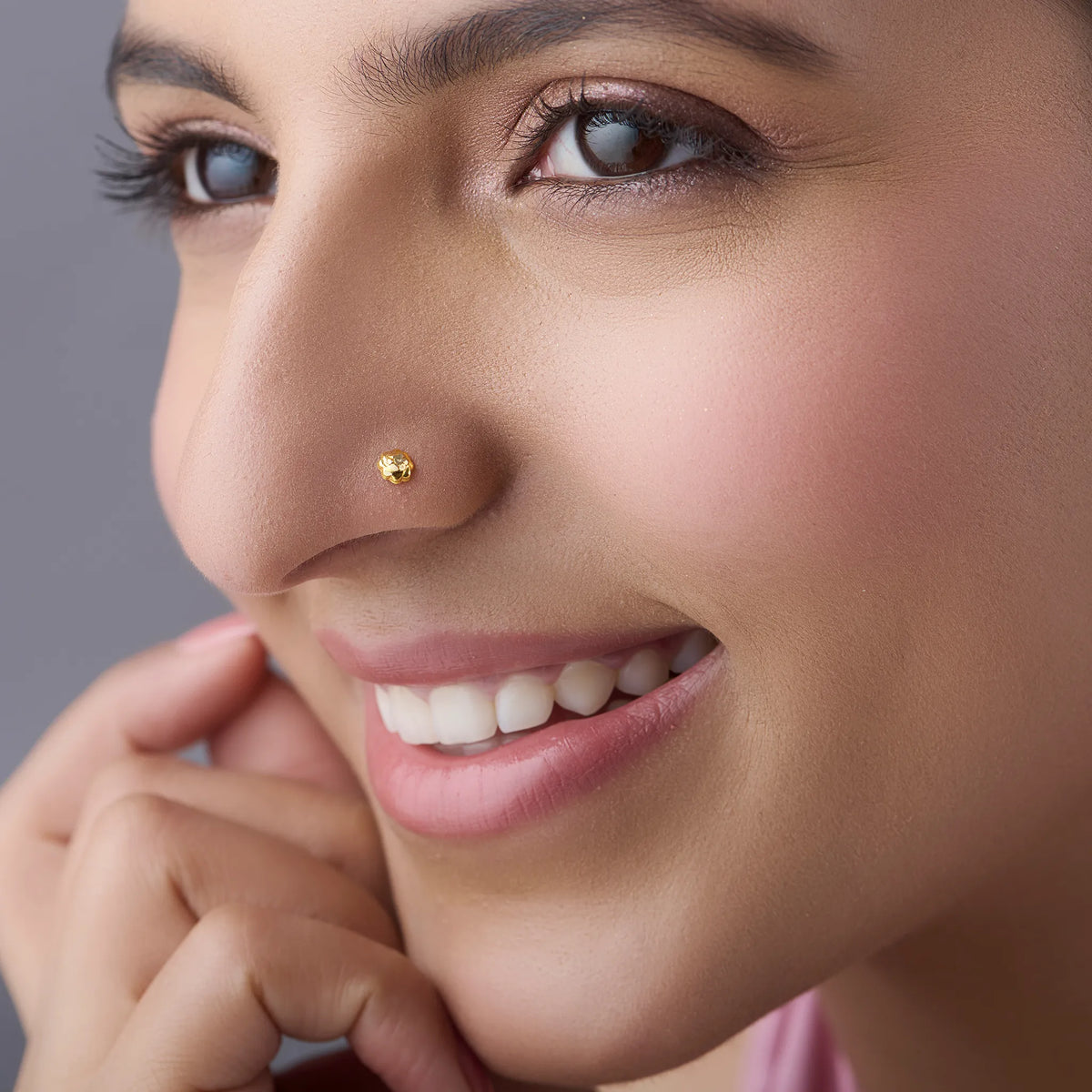 Woman wearing a minimalist gold nose pin showcasing an elegant everyday look