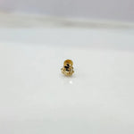 Tiny 18K nose pin gold captured on a marble-like surface highlighting its subtle shine