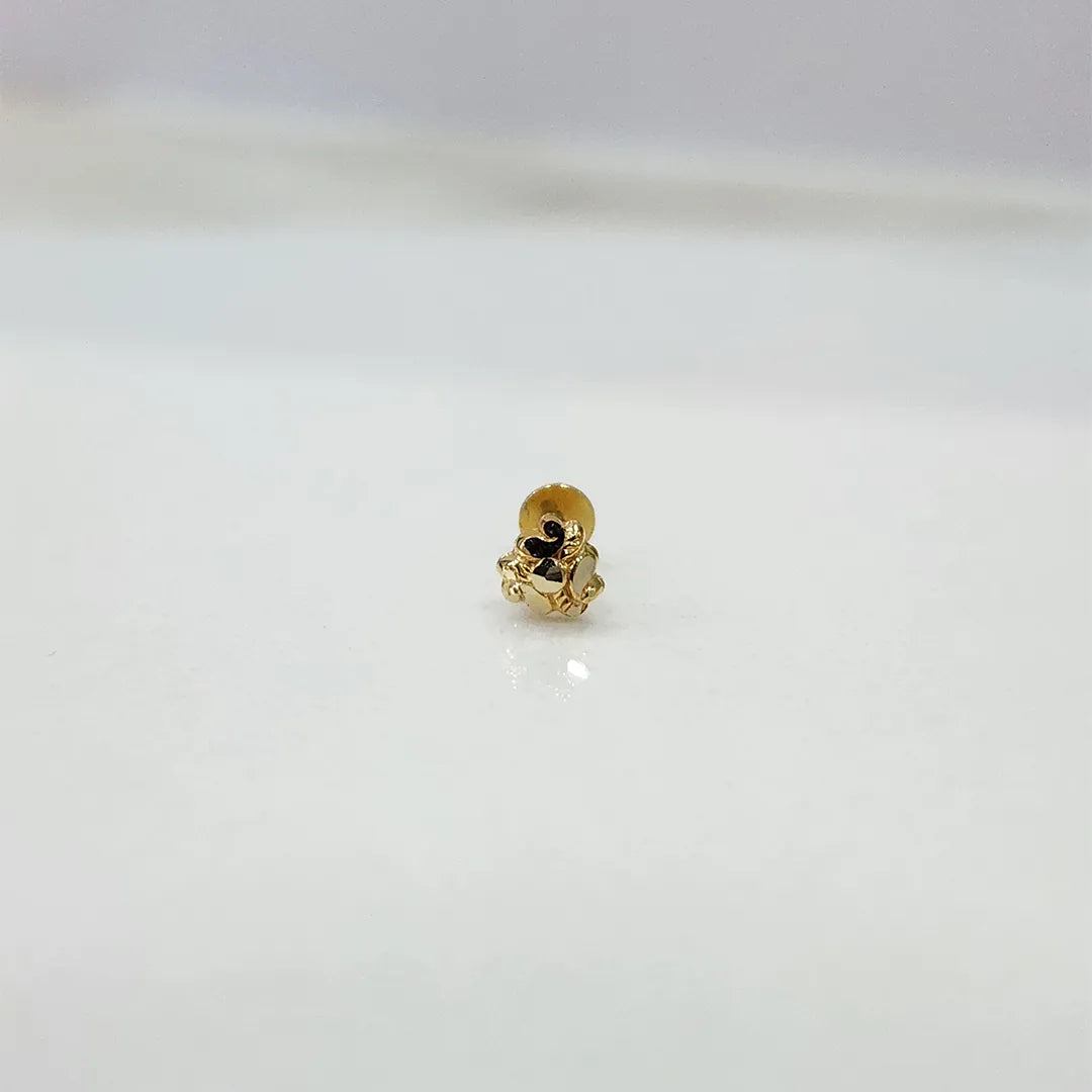 Tiny 18K nose pin gold captured on a marble-like surface highlighting its subtle shine