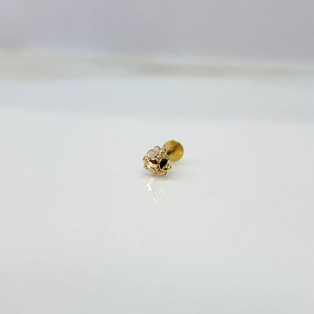 Small floral 18K nose pin gold placed on a white background showing fine detailing