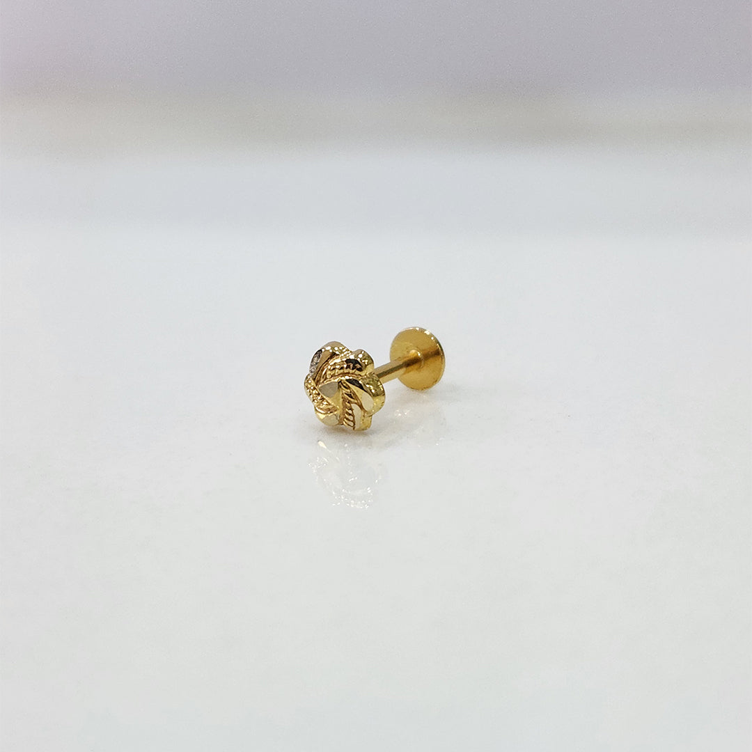 Side view of tiny 18K nose pin gold captured on a white surface highlighting its polished finish