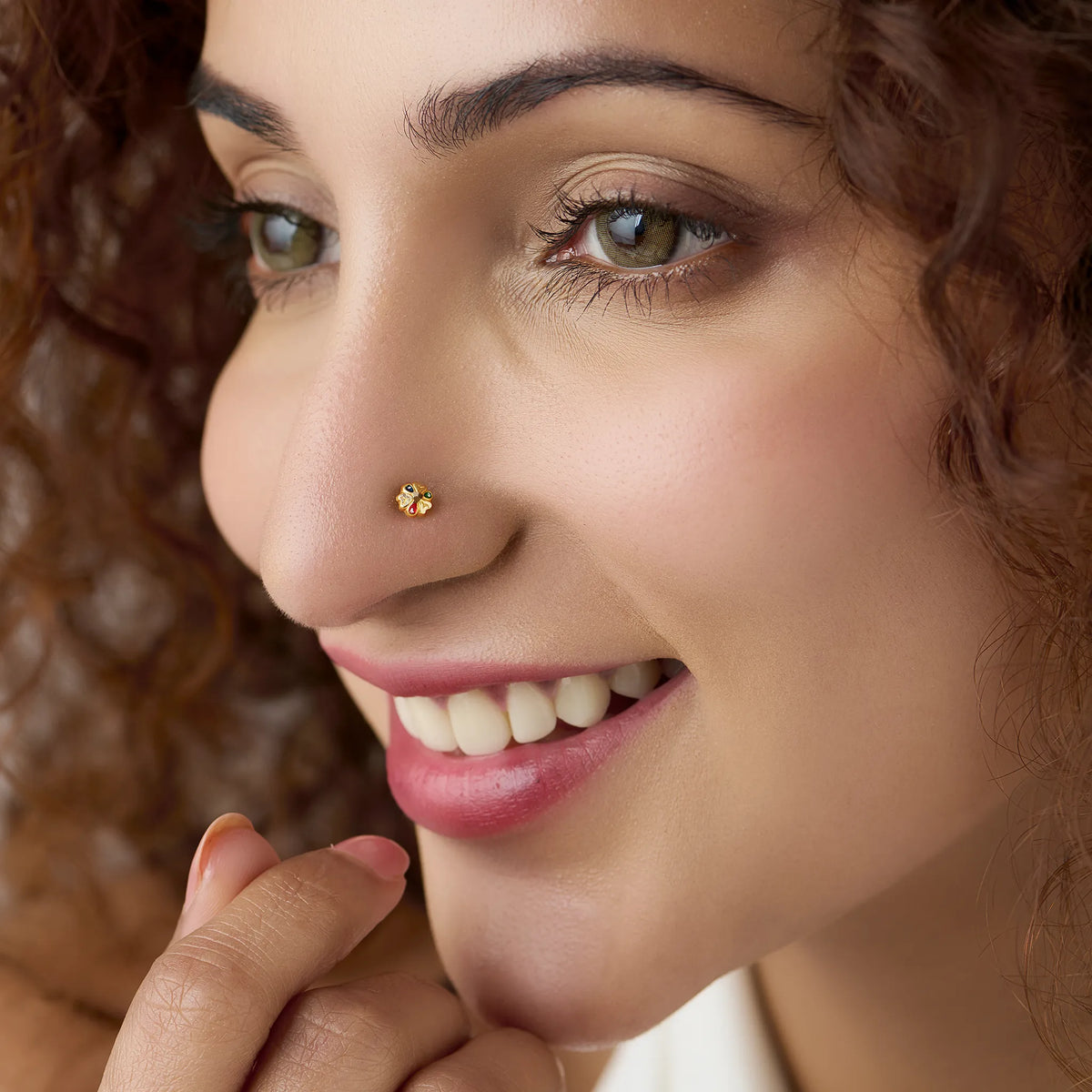 Woman wearing a colourful 18K nose pin gold showcasing an elegant traditional-inspired look