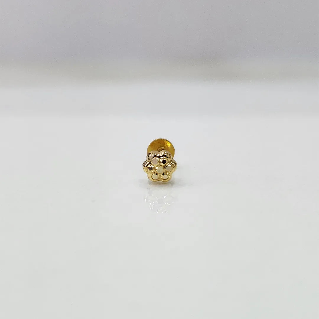 Side view of tiny floral 18K nose pin gold on a white surface highlighting its smooth finish