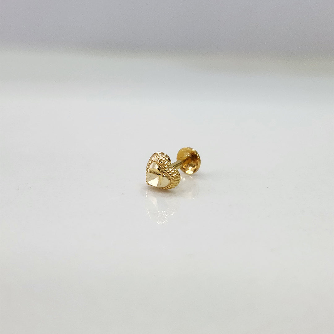 Side view of heart motif 18K nose pin gold placed on a white surface displaying its polished finish