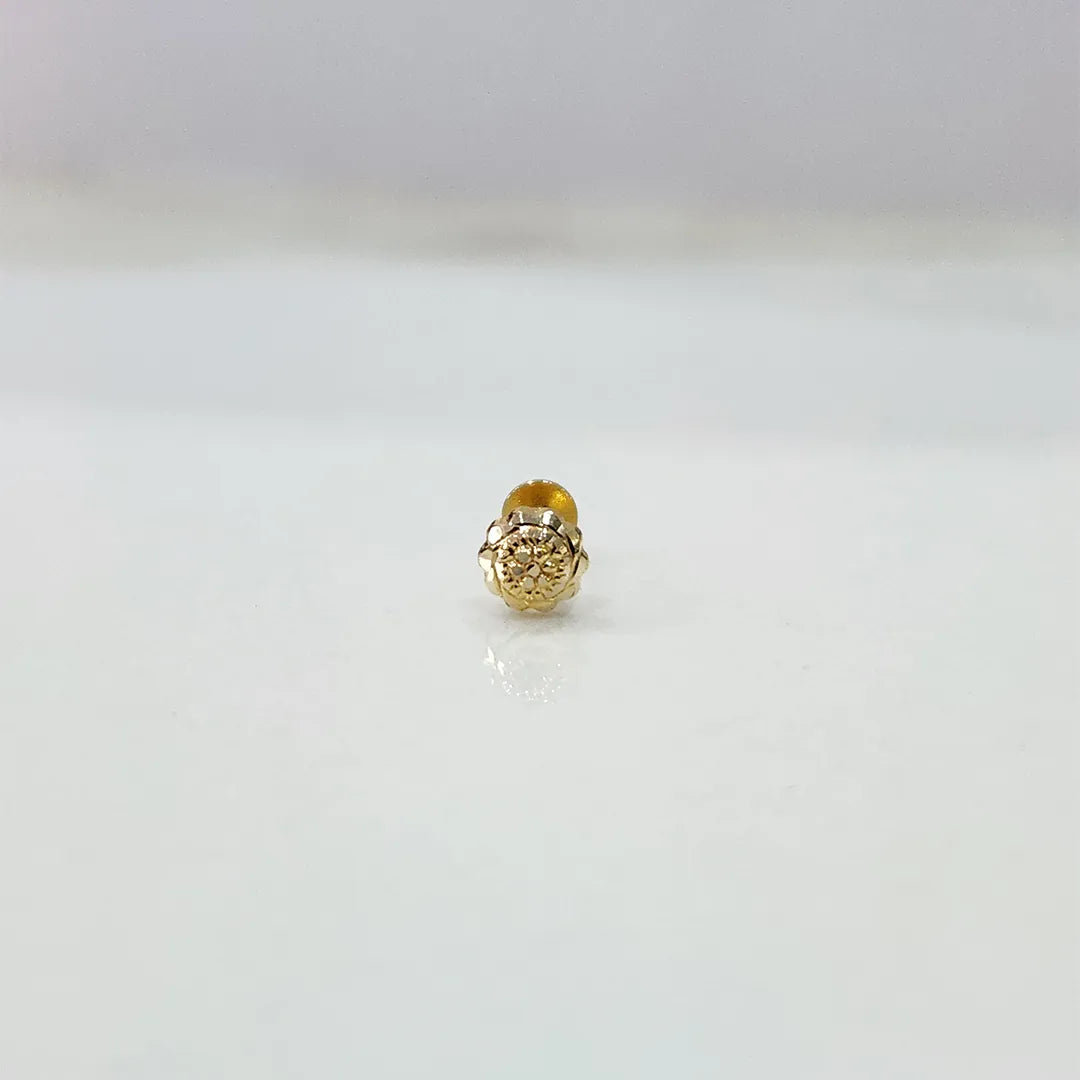 Small 18K nose pin gold placed on a white background capturing its fine handcrafted detailing