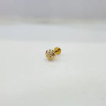 Tiny 18K nose pin gold photographed on a smooth white surface showing its polished finish
