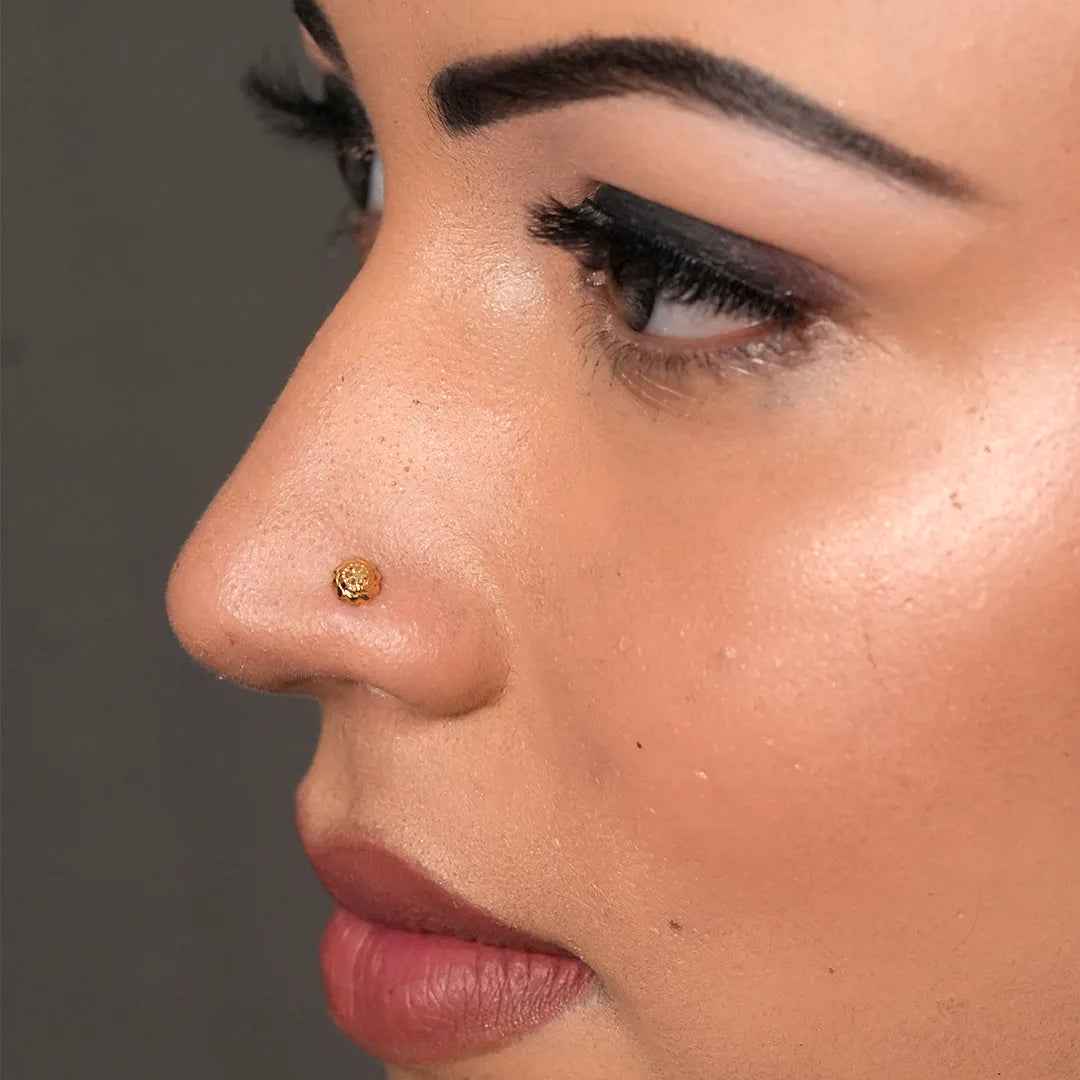 Side profile of a woman wearing a tiny 18K nose pin gold showing its subtle and refined appearance