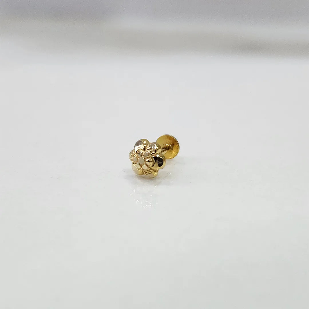 Small floral 18K nose pin gold displayed on a white surface capturing its fine textured design