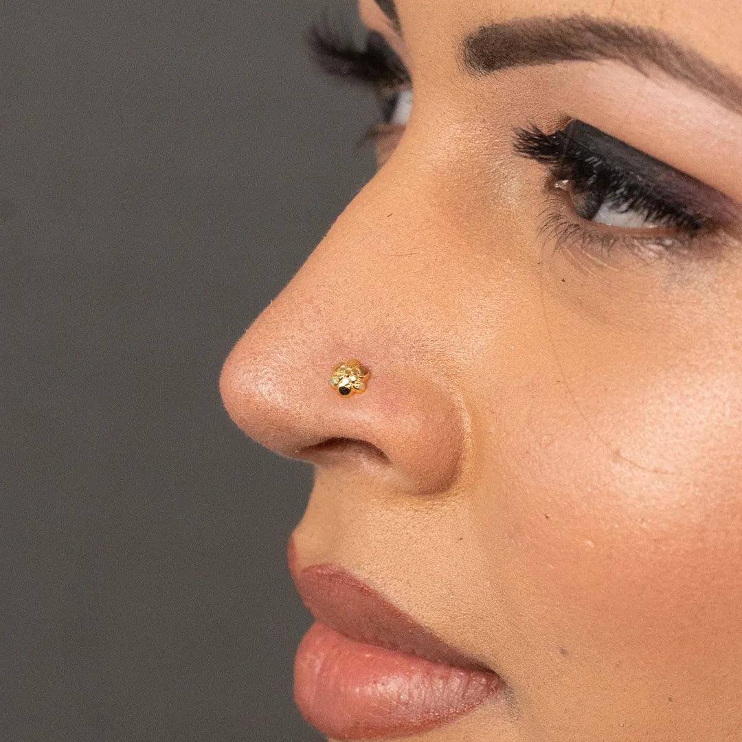 Woman wearing floral 18K nose pin gold showcasing a delicate and elegant traditional look