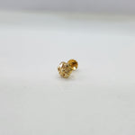 Small floral 18K nose pin gold on a white background capturing its intricate miniature design