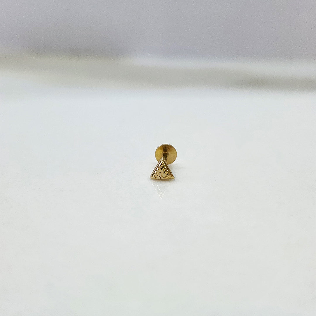 Tiny triangle 18K nose pin gold photographed on a white background showing fine geometric detailing