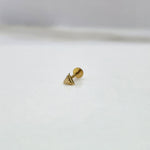 Small triangle 18K nose pin gold displayed on a white surface showcasing its tiny, sleek craftsmanship