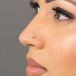 Woman wearing triangle 18K nose pin gold highlighting a clean and contemporary traditional look
