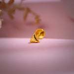 Triangle-shaped 18K nose pin gold placed on a soft pink background showing its modern minimalist design