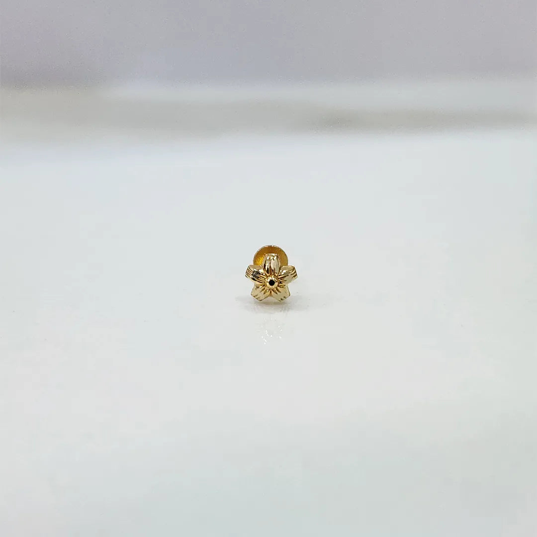 Tiny floral 18K nose pin gold displayed on white background showing intricate petal detailing