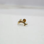 Small dolphin motif 18K nose pin gold placed on a white surface showcasing delicate craftsmanship