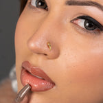 Woman wearing a delicate 18K nose pin gold showcasing an elegant everyday look
