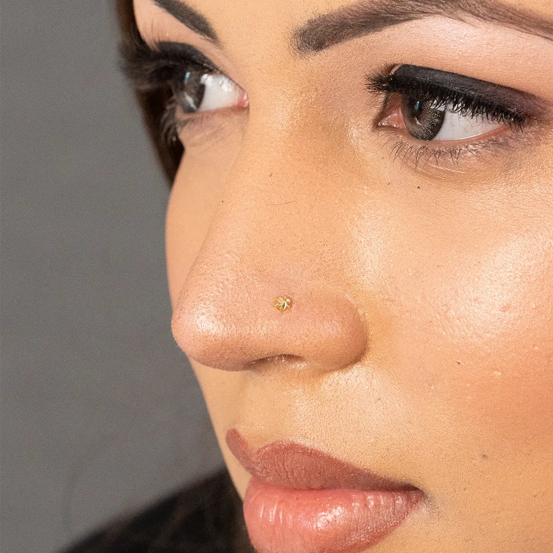 Woman wearing a small gold nose pin showcasing a minimal elegant look