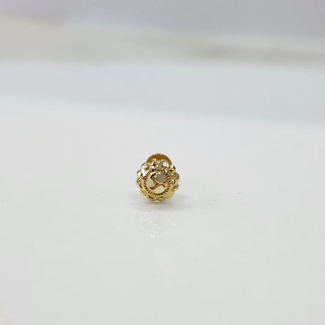 Close-up of tiny gold nose pin placed on a white background for clarity