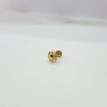 Small gold nose pin on a white surface showing delicate detailing