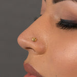 Woman wearing a tiny gold nose pin showcasing a simple elegant look