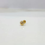 Close-up of delicate gold nose pin placed on a white marble-like background
