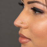 Woman wearing a tiny gold nose pin styled for a simple elegant look