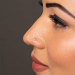 Woman wearing small round gold nose pin showing elegant and simple everyday look