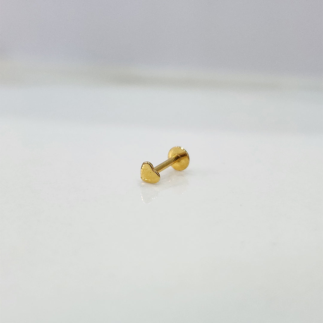 Side view of delicate 18K nose pin gold placed on a white surface reflecting its subtle shine