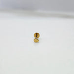 Front view of a small plain 18K gold nose pin on a white surface highlighting its minimal circular design