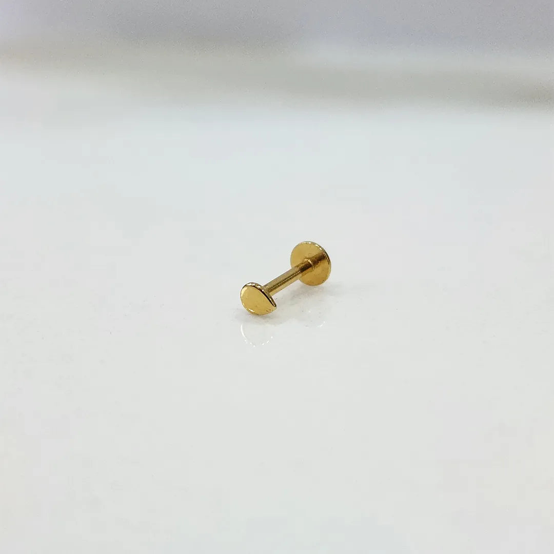 Side view of a plain 18K gold nose pin placed on a white background displaying the straight post and flat back