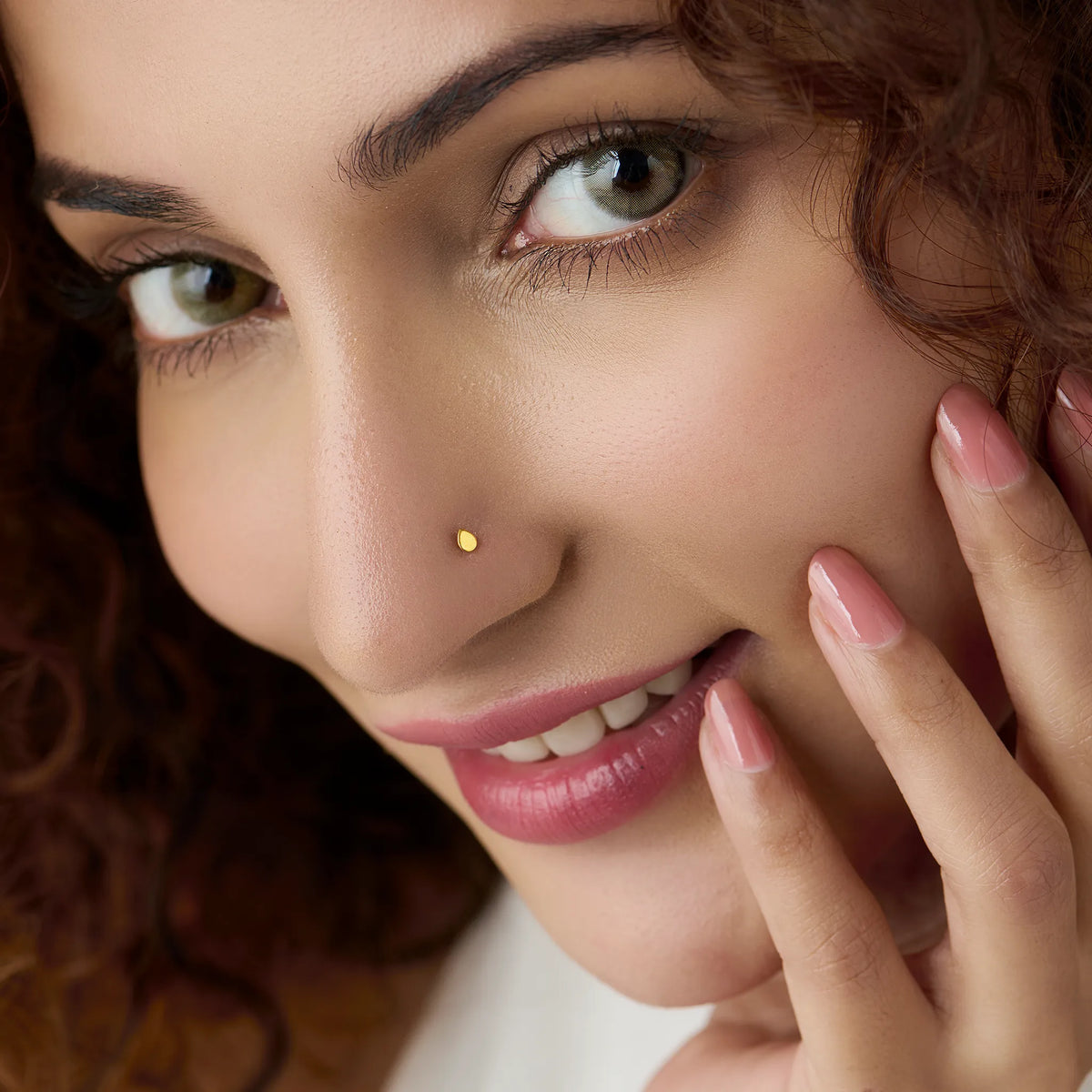Front profile of a woman wearing a minimal plain gold nose pin highlighting subtle everyday elegance