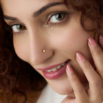 Front profile of a woman wearing a minimal plain gold nose pin highlighting subtle everyday elegance